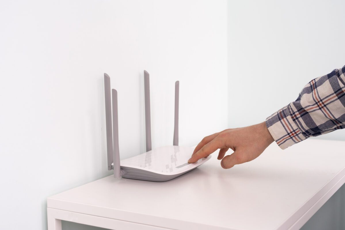 Peilsender kaufen - Salind GPS Peilsender 2025 a hand push the power on button of the wifi router 2022 11 09 03 51 56 utc 1199x800 - Peilsender kaufen - Salind GPS Peilsender 2025