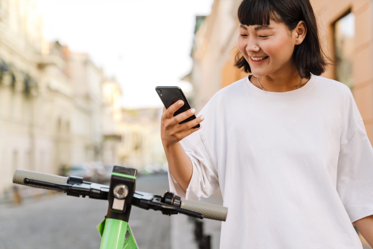 smiling young asian woman using an app on smartpho 2021 12 09 19 51 01 utc 1199x800 - GPS Tracker E Scooter kaufen - 2025