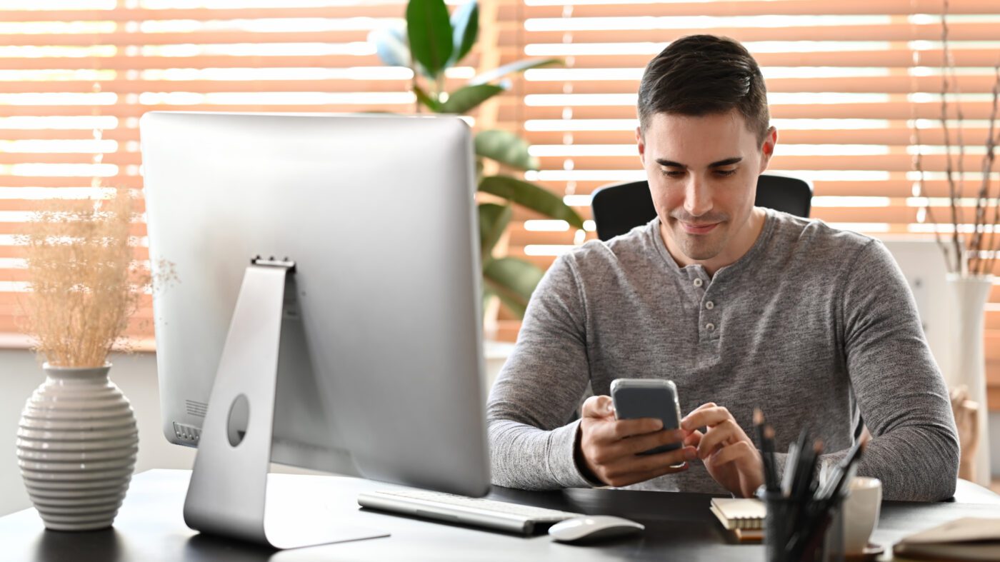 attractive man sitting at home office and using sm 2022 02 09 01 04 28 utc 1 1400x787 - GPS Tracker Wohnwagen - GPS Ortung Wohnwagen