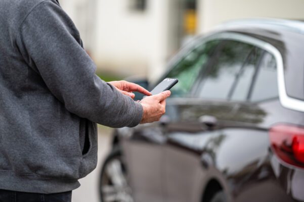 man with smartphone standing next to the car usin 2022 09 20 00 59 45 utc 601x400 - Auto Diebstahlschutz erhöhen