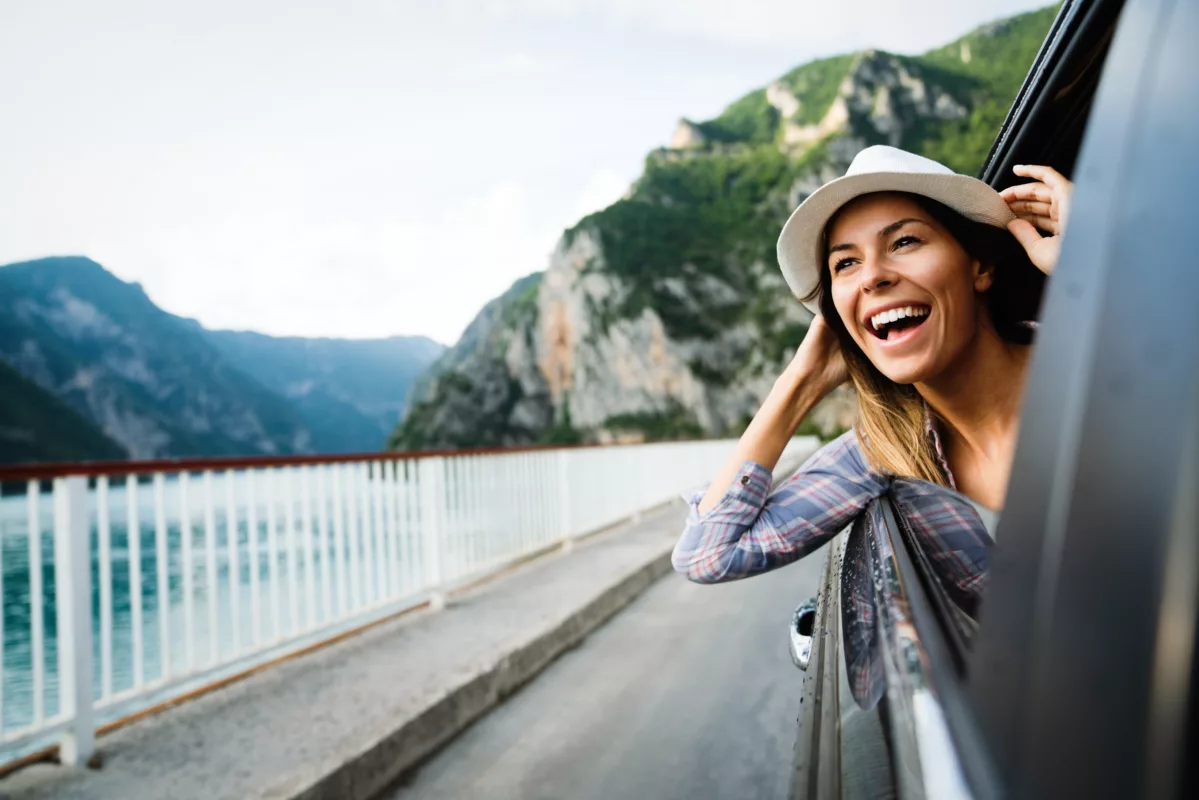 Roadtrip mit dem Auto - Unvergessliche Abenteuer erleben woman in car road trip waving out the window smili 2022 01 18 23 40 11 utc 1199x800 - Roadtrip mit dem Auto - Unvergessliche Abenteuer erleben